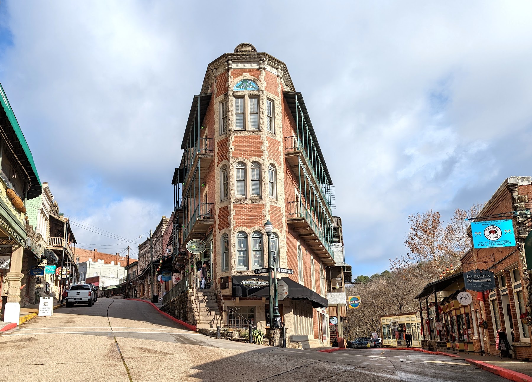 Colorful Victorian-style buildings lining a curved street in downtown Eureka Springs.