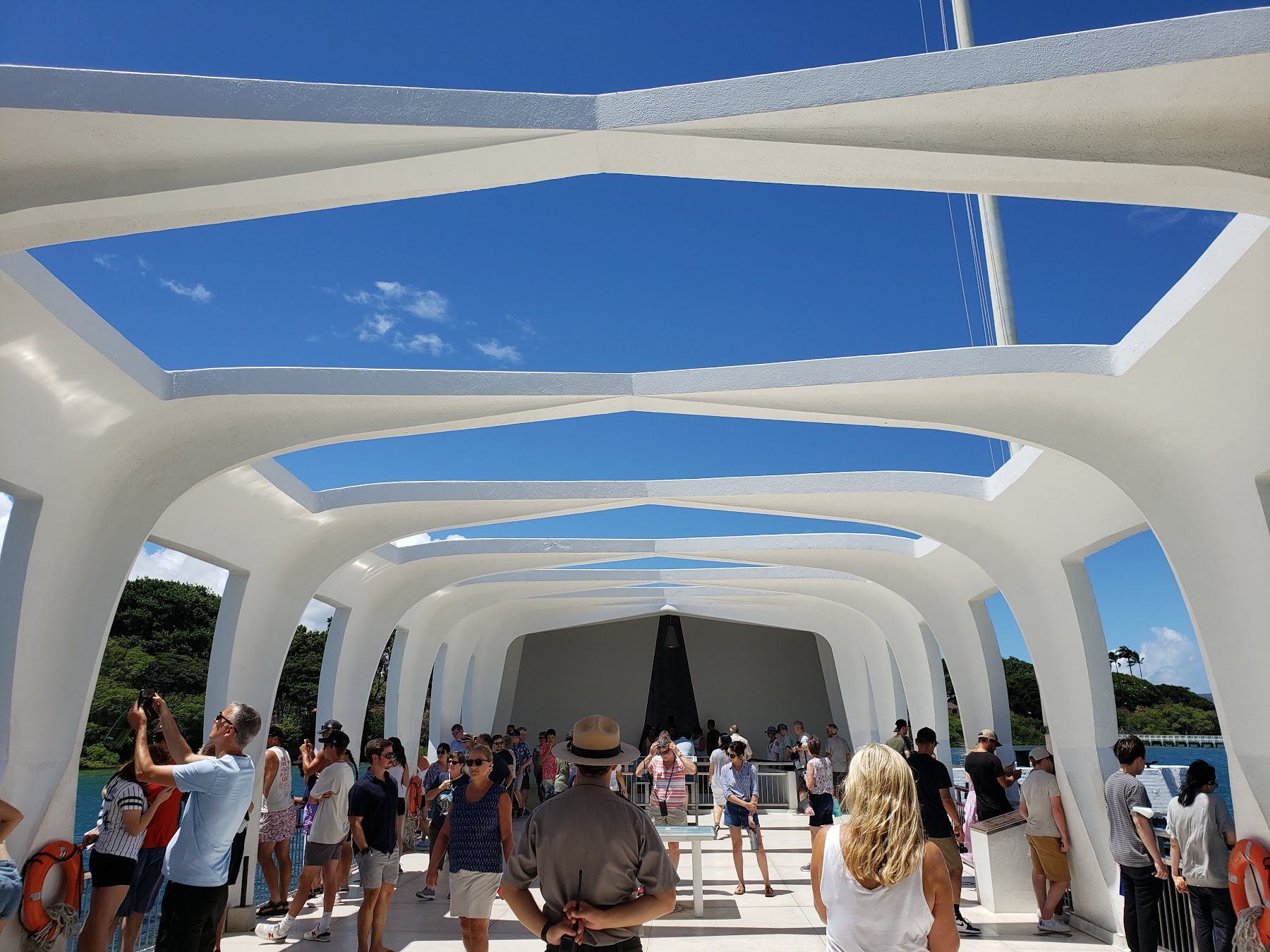 The architectural span of the USS Arizona Memorial on the blue waters of Pearl Harbor