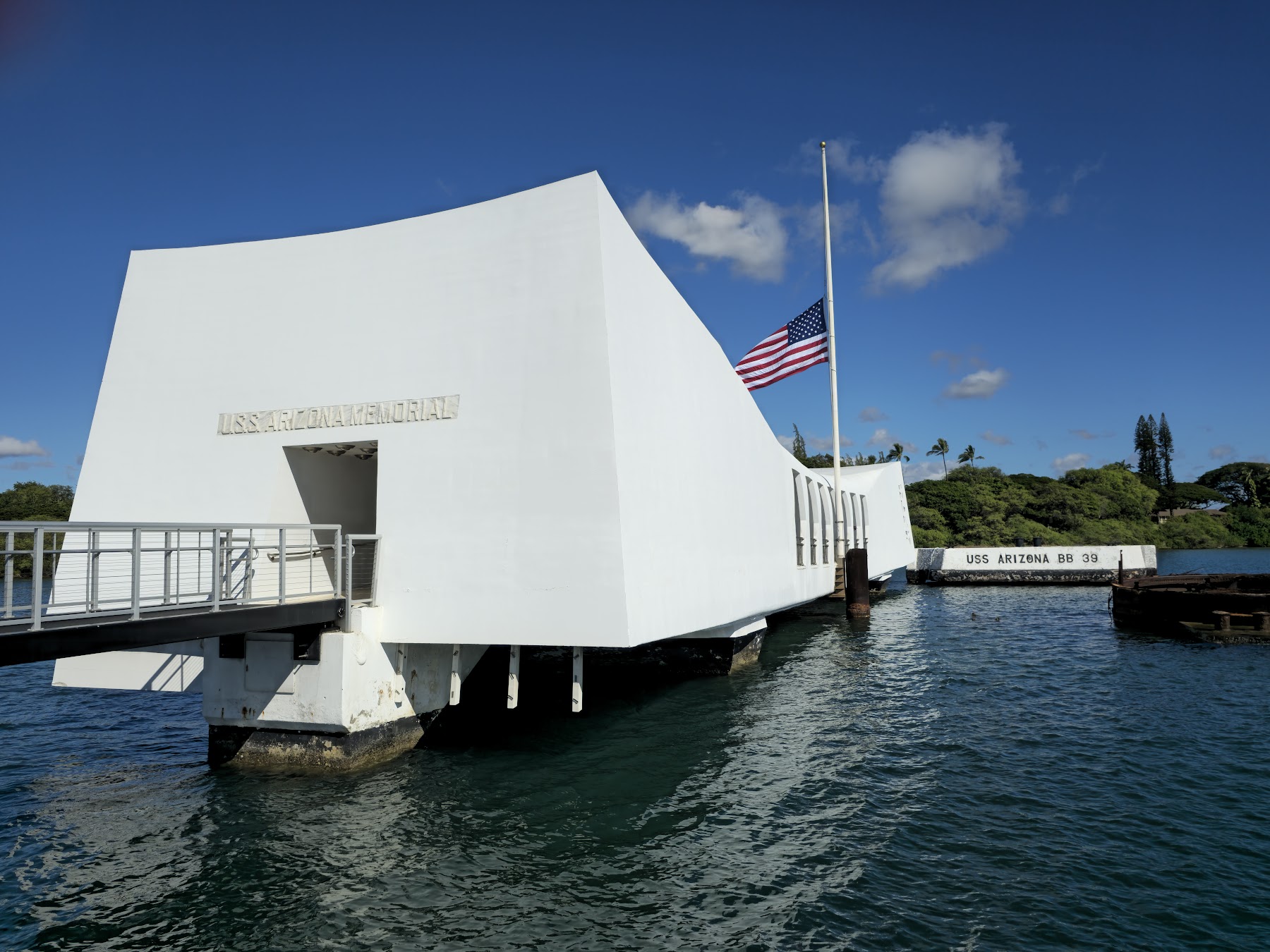 The white structure of the USS Arizona Memorial spanning the water at Pearl Harbor.