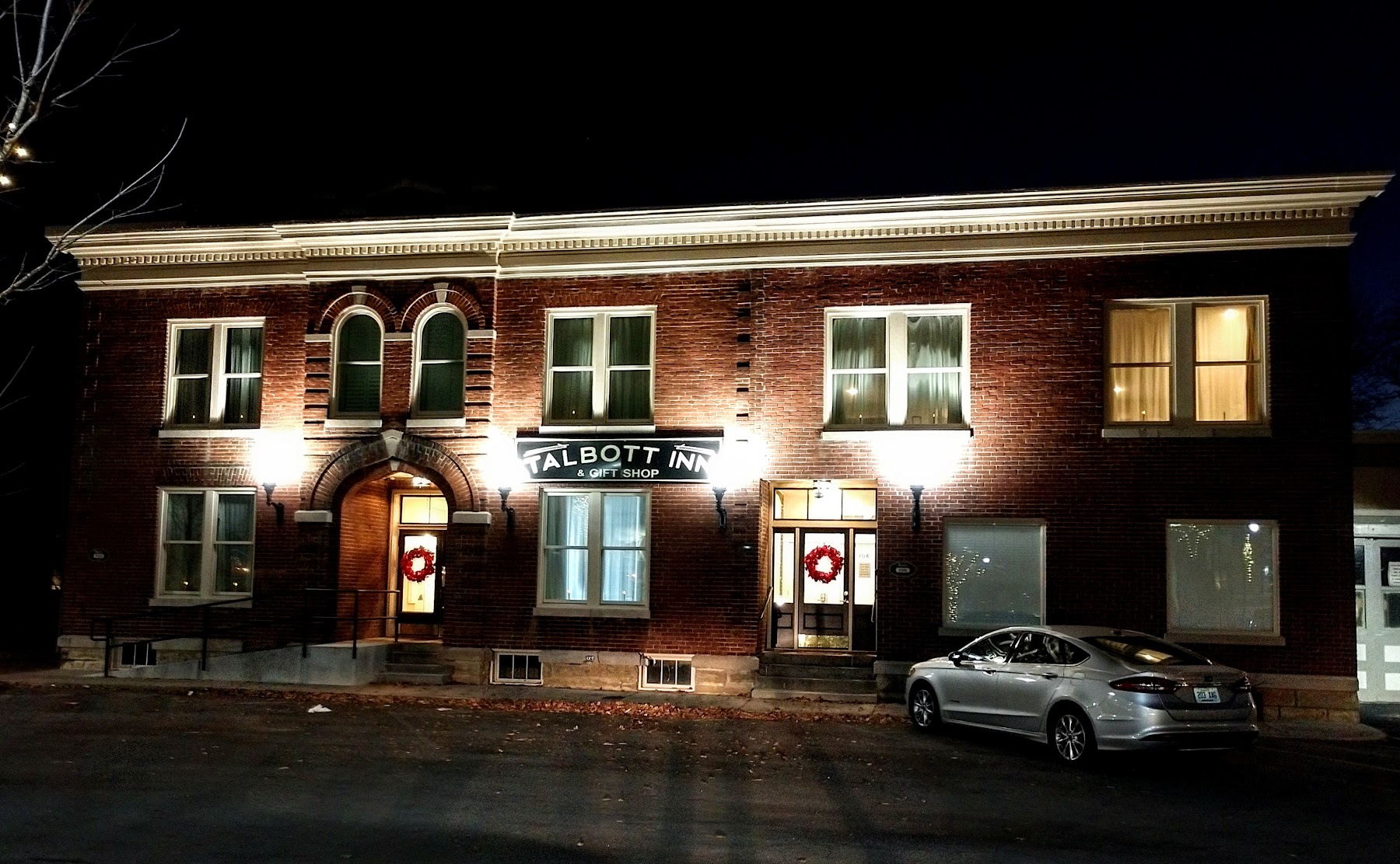 The historic stone facade of the Old Talbott Tavern in Bardstown, Kentucky, with an American flag hanging.