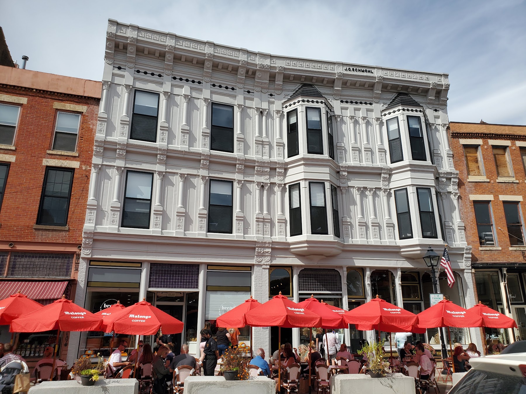 A wide, historic main street in Galena, Illinois, lined with red brick buildings under a clear blue sky.